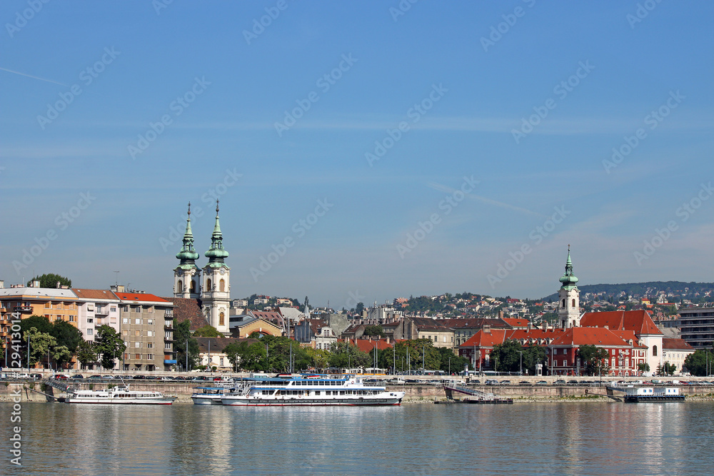 Danube riverside with churches buildings and boats Budapest Hung