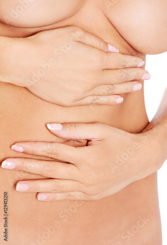 Young woman holding hand on nude belly