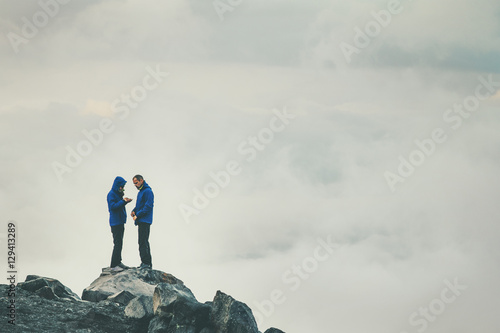 Couple Travelers in love standing on cliff together enjoying cloudy foggy mountains landscape Travel Lifestyle freedom concept adventure vacations outdoor