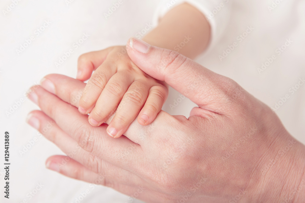 Baby hand gently holding adult's finger (Soft focus and blurry) Baby hand gently holding adult's finger (Soft focus and blurry)