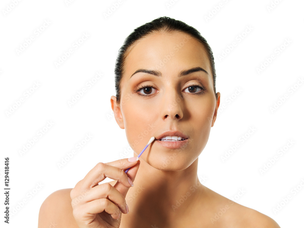 Young woman putting ear stick into mouth Young woman putting ear stick into mouth