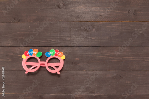 Pink glasses with Happy Birthday massage is on the wooden backgr