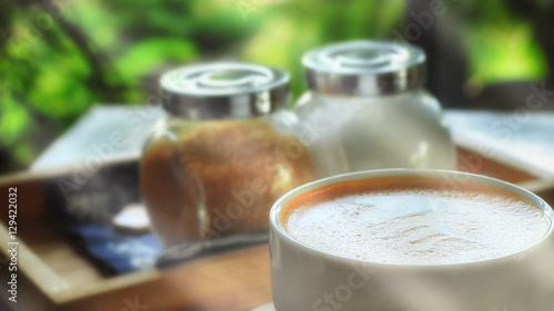 Cup of coffee on wooden table and window view background