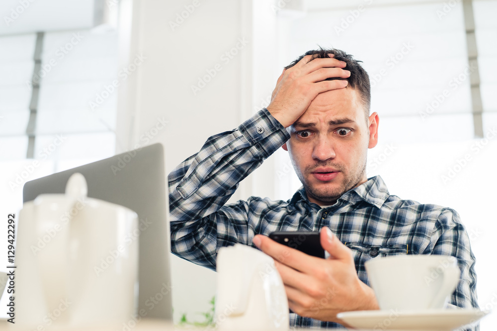 Worried shoked man looking on laptop at cafe Worried shoked man looking on laptop at cafe