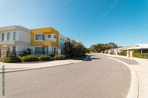 Asphalt road with modern terrace house in front on blue sky background. Yanchep Beach Town , Perth , Western Australia . © jamesteohart