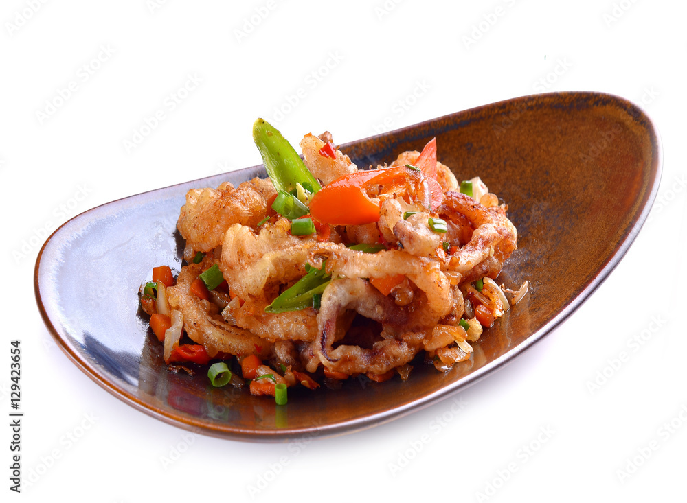 Spicy fried seafood with basil leaves on white background Spicy fried seafood with basil leaves on white background