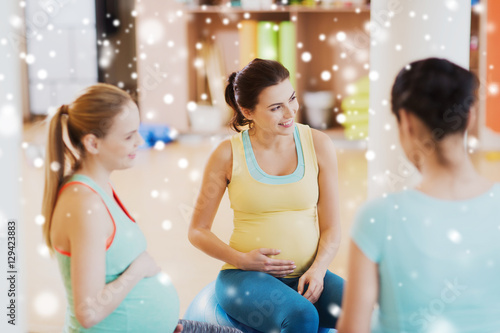 happy pregnant women sitting on balls in gym