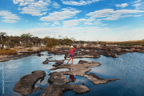 Young woman standing on the river between rocks