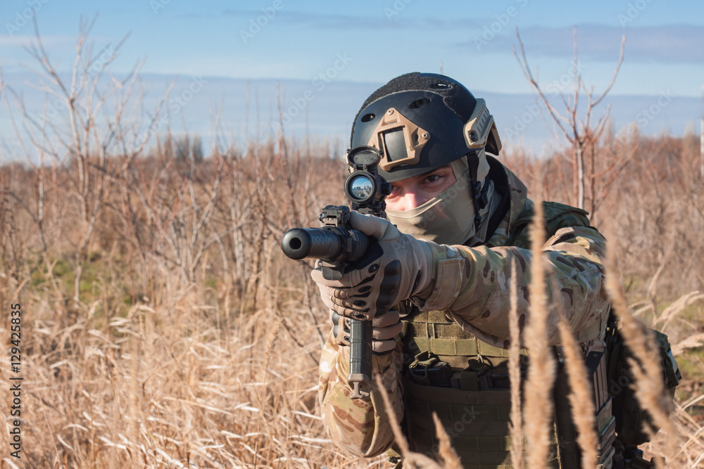 Close up picture of airsoft soldier with a combat rifle outdoor