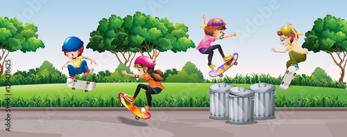 Four kids skateboarding in park