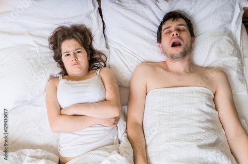 Angry woman cant sleep and listening her husband snoring. photo