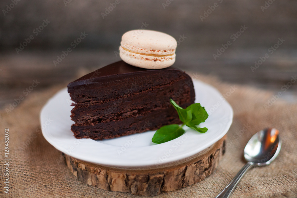 A piece of chocolate cake with fresh mint on the table, close-up A piece of chocolate cake with fresh mint on the table, close-up