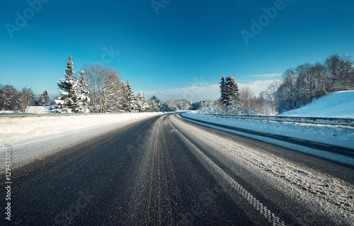Asphalt road in snowy winter on beautiful frosty sunny day © candy1812