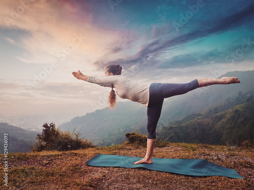 Woman doing Ashtanga Vinyasa Yoga asana Virabhadrasana 3 Warrior photo