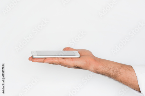 Hand of a man with mobile smart phone isolated on gray background. Presentation of a innovation device of technology. Commercial modern presentation concept.