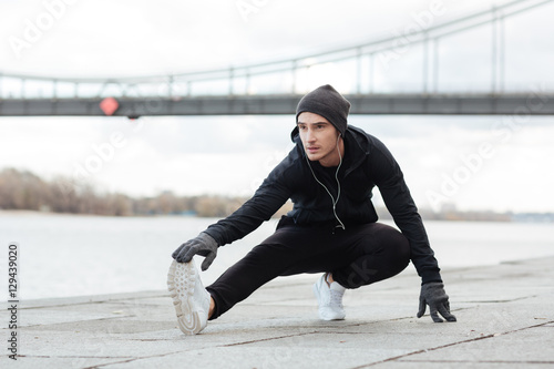 Fototapeta Naklejka Na Ścianę i Meble -  Man athlete listening to music and working out outdoors