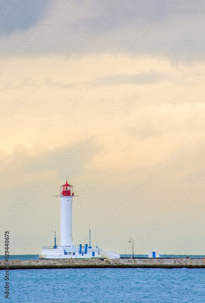 The lighthouse on the background of the cloudy sky