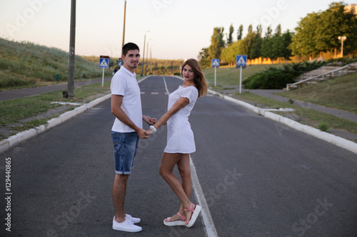 Young beautiful fashion couple in love having fun outdoor. Sweet kiss of pretty couple standing on road