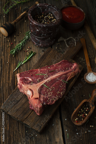 Raw Steak T-Bone with oregano and rosemary, salt, pepper and ket