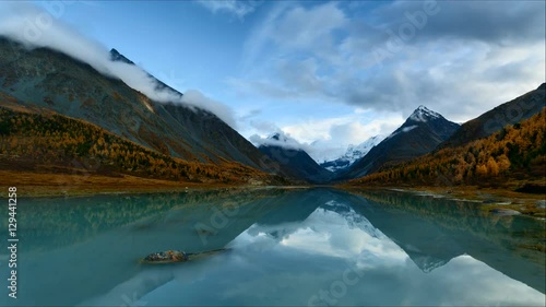 Time Lapse. Belukha Mountain and Highland Lake Akkem in autumn sunset. Altay Mountains, Russia.
