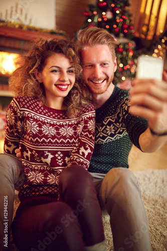 Couple photographing Christmas selfie together