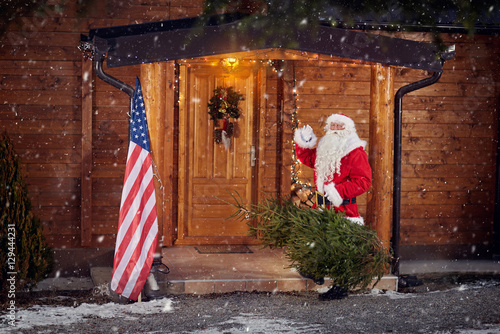 Real Santa Claus front his wooden house © luckybusiness