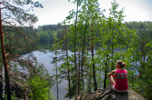 woman laying on cliff an relaxing above the lake Yastrebinoye, Priozersky district in Leningrad region, Russia
