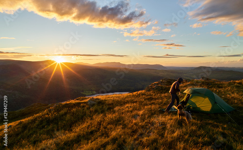 Fotografia, Obraz A hiker camping on the mountain summit of Place Fell in the Lake District