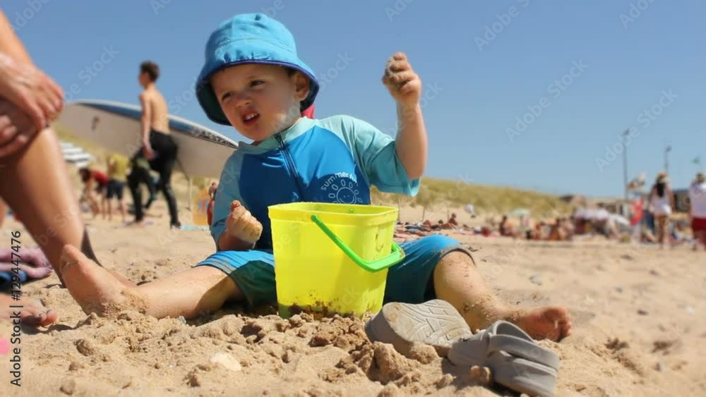 Little boy playing on a busy beach Little boy playing on a busy beach