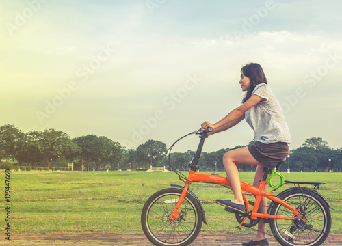young woman riding a bicycle in a park., healthy lifestyles