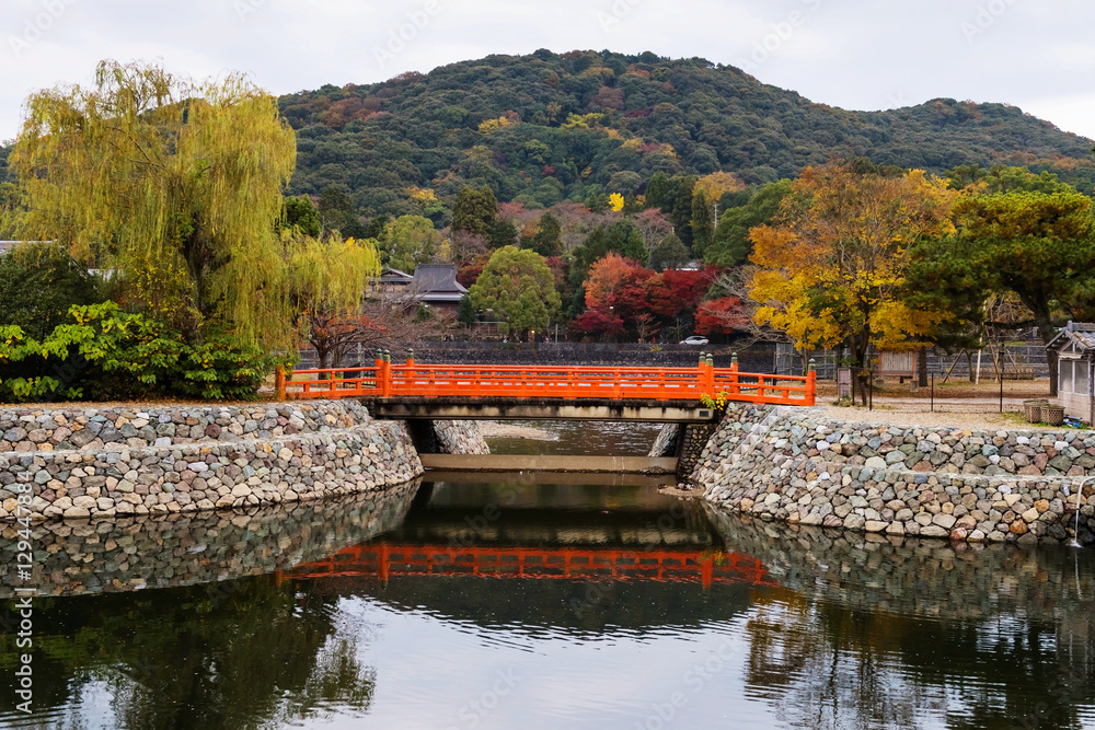 Fototapeta premium Red bridge at Uji River with autumn colors, Kyoto
