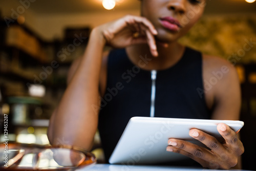 African business woman working on tablet in the cafe at lunch, close up