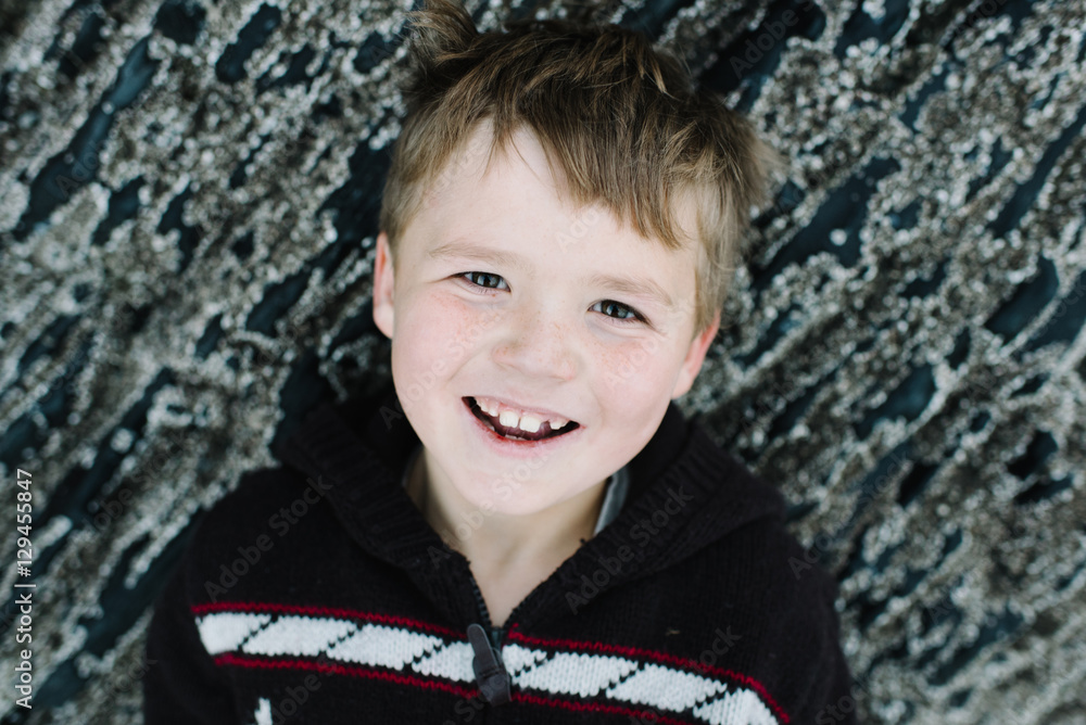 Portrait of boy, smiling, leaning against rocks Portrait of boy, smiling, leaning against rocks