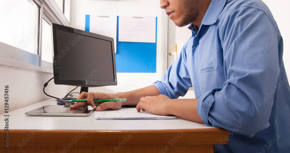 Doctor working at desk in the hospital with his computer.