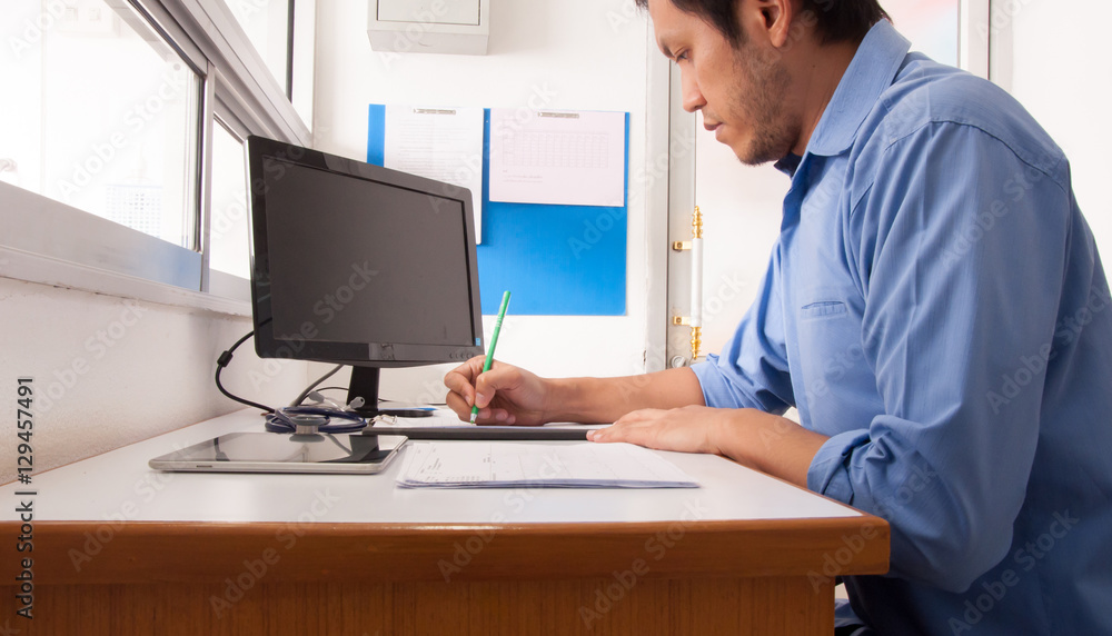 Doctor working with computer at desk in the hospital