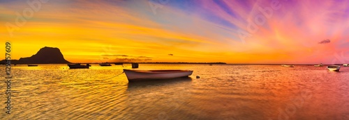 Obraz na płótnie Fishing boat at sunset time. Le Morn Brabant on background. Pano