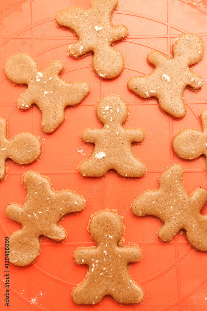 Above view of sweet homemade Christmas cookies. Sweet dough for gingerbread men prepared on silicon baking mat. Above view of sweet homemade Christmas cookies. Sweet dough for gingerbread men prepared on silicon baking mat.