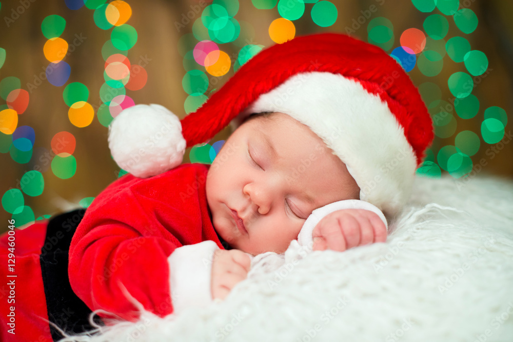 Portrait of newborn baby in Santa clothes lying under Christmas tree. Portrait of newborn baby in Santa clothes lying under Christmas tree.