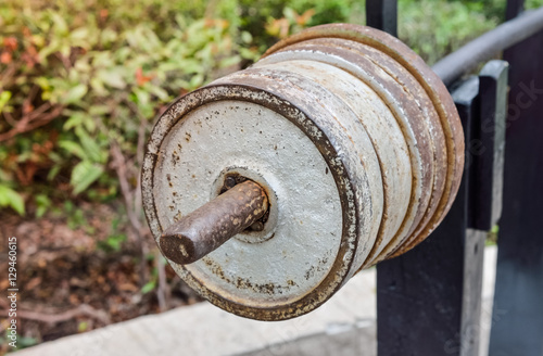 Close up of old dumbbell. Outdoor view in the park (healthcare, sport, fitness)