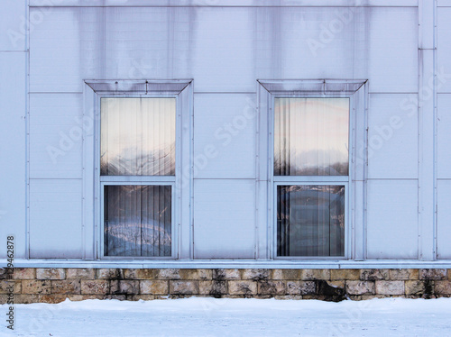 two rectangular windows with siding imitating steel, on large sports complex © wolfness72