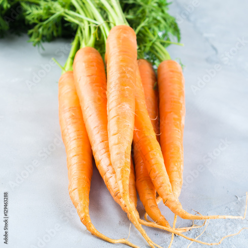 Fresh carrots on gray background. Closeup square