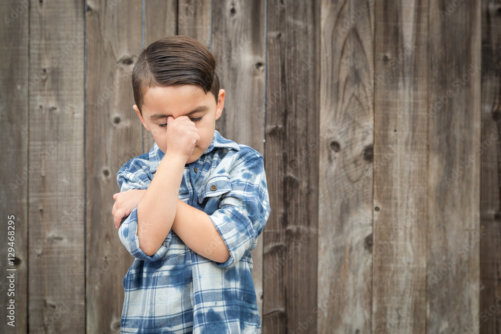 Young Frustrated Mixed Race Boy With Hand on Face Against Wooden Fence. Young Frustrated Mixed Race Boy With Hand on Face Against Wooden Fence.