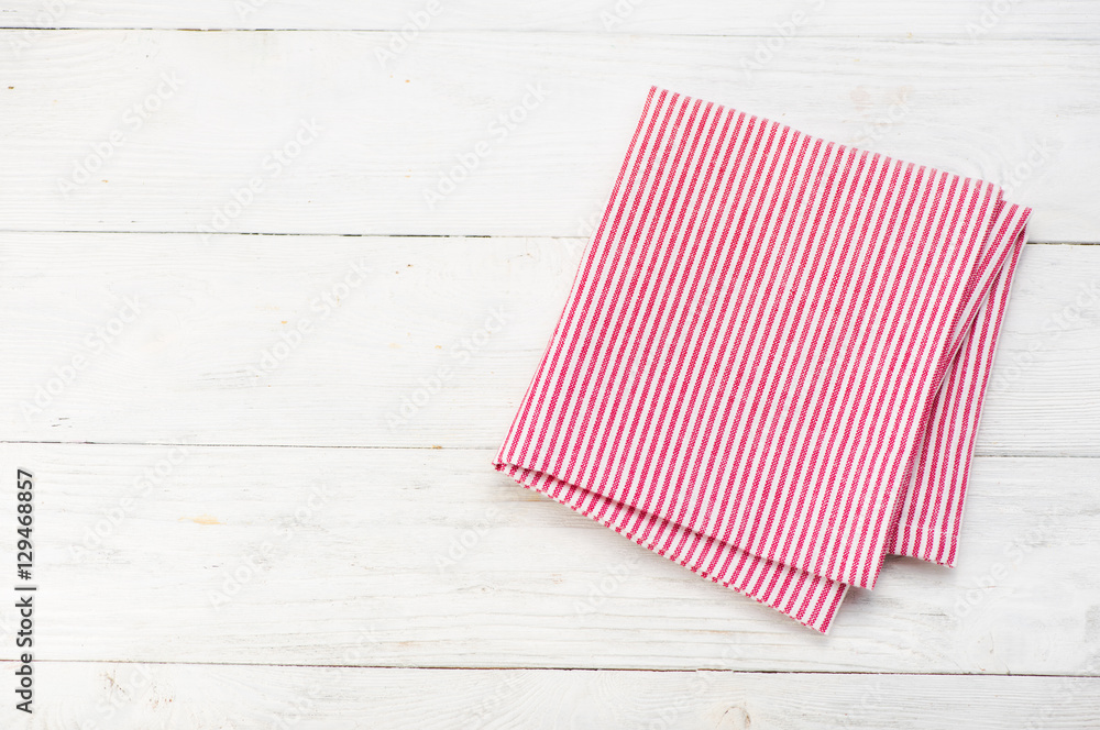 Red rustic napkin isolated on white wooden table. Copy space. Top view. Red rustic napkin isolated on white wooden table. Copy space. Top view.