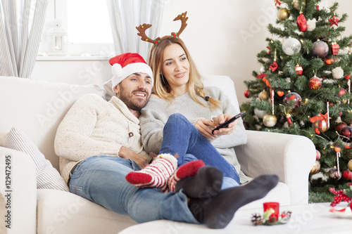 Couple in love watching TV at Christmas Eve