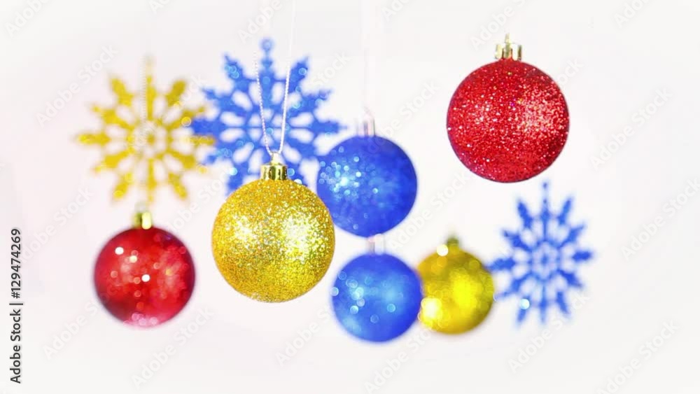 Christmas colorful background. Close up of beautiful New Year blurry golden, red, blue round shining balls and snowflakes hanging on silver ropes isolated on white. Real time full hd video footage. Christmas colorful background. Close up of beautiful New Year blurry golden, red, blue round shining balls and snowflakes hanging on silver ropes isolated on white. Real time full hd video footage.