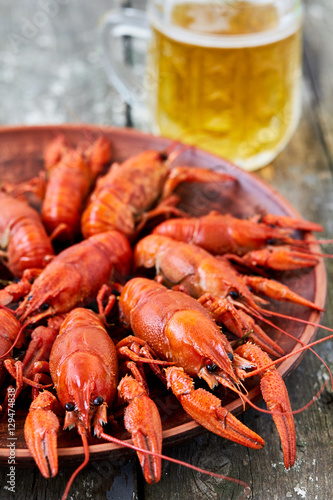 Red boiled crayfish and a glass of beer on a wooden background