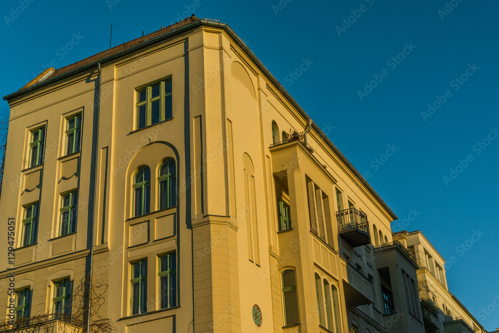 yellow and high contrasted apartment building with clear blue sky