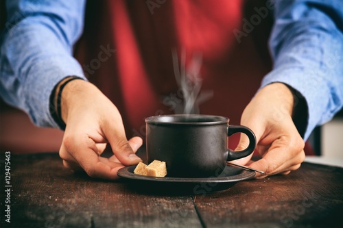 Barista in front of a cup of coffee