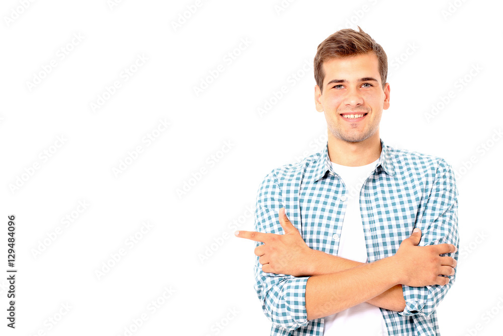 Young man showing something by his finger on white background. Mock up.Copy space Young man showing something by his finger on white background. Mock up.Copy space