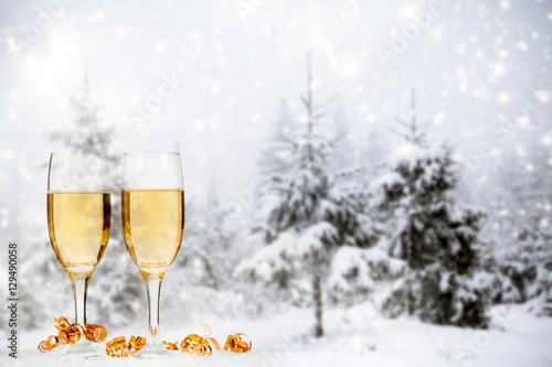 Christmas decorations and champagne against winter background